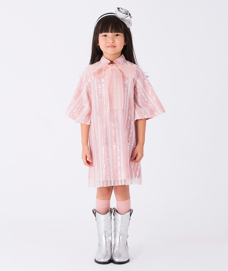 A soft pink and white striped dress with airy wide sleeves, an organza bow and glitter