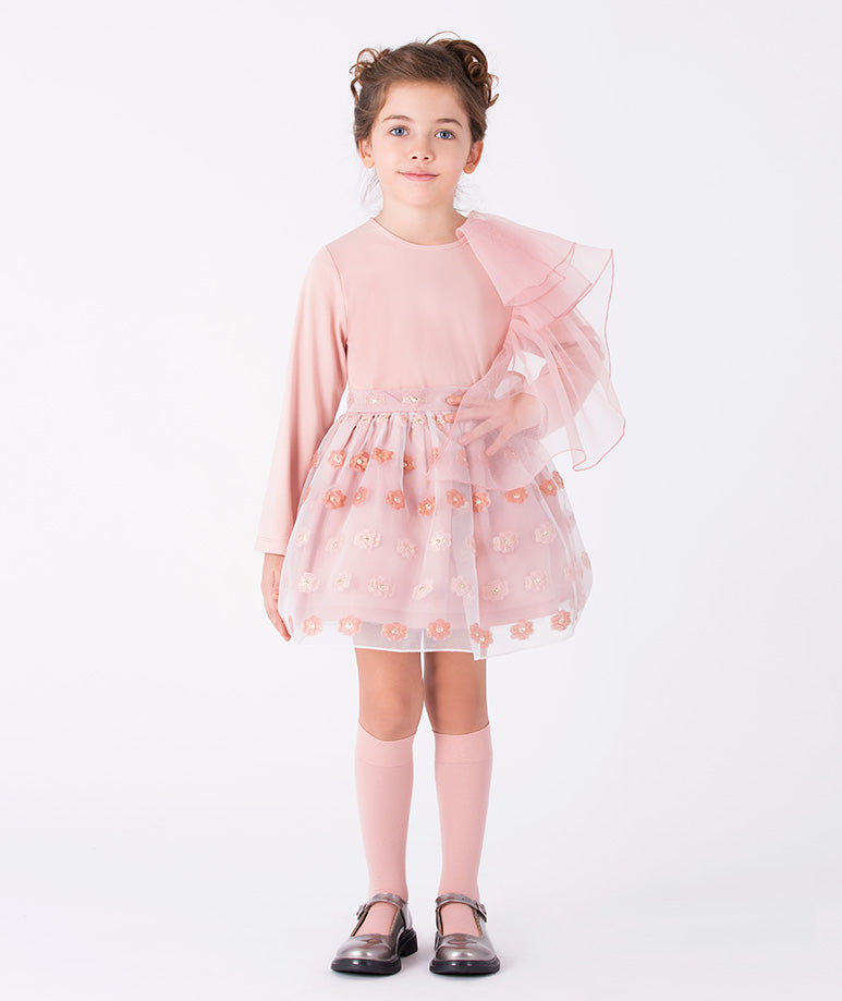 a soft pink top with oversized tulle ruffle for modern volume and a textured floral skirt