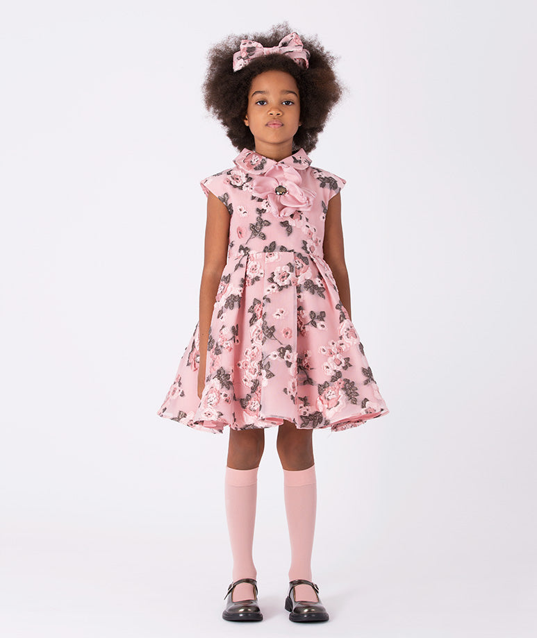 A twirl-worthy dress adorned with whimsical floral prints in soft pink hues
