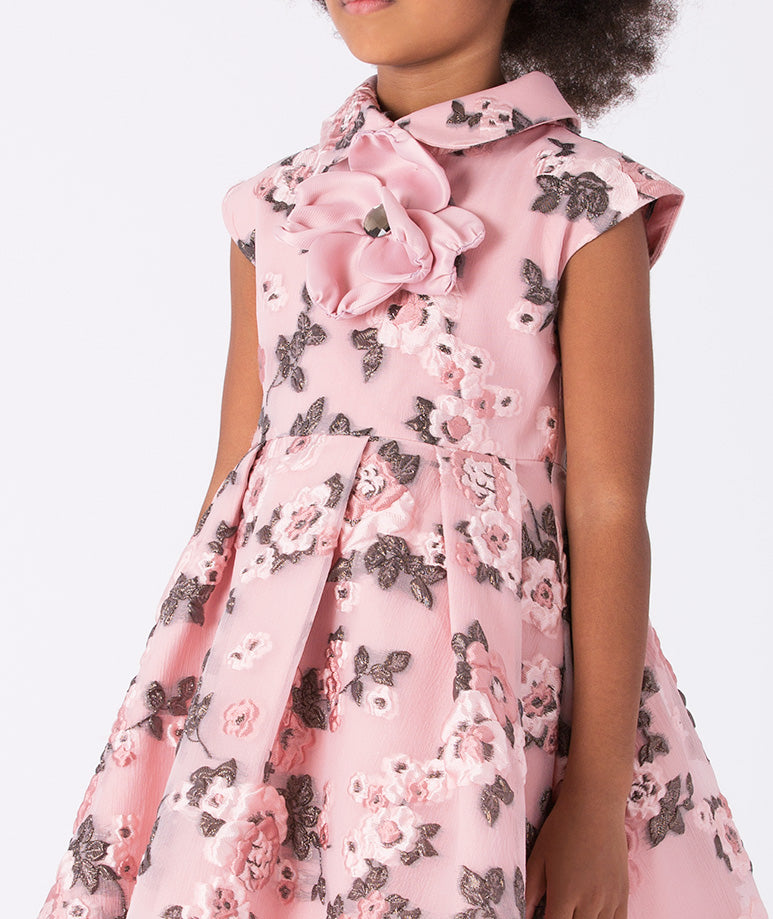 A dress adorned with whimsical floral prints in soft pink hues