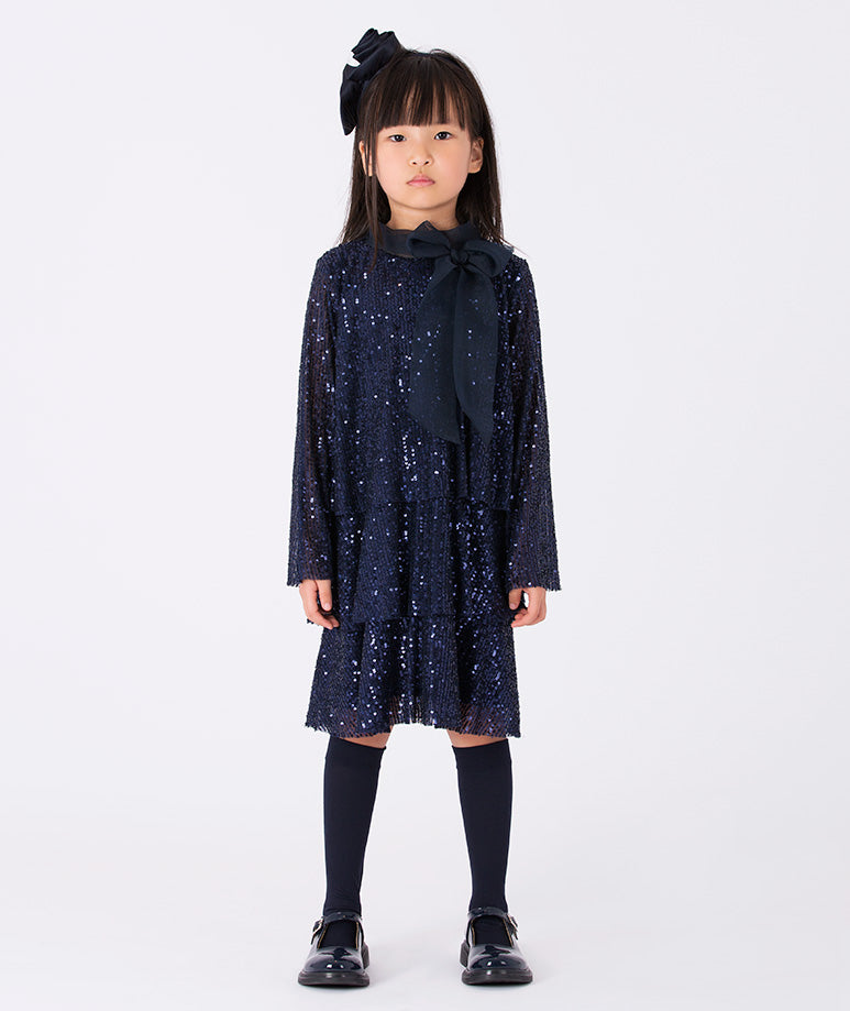 A navy glitter dress with long sleeves and a soft, sheer bow—a playful mix of sparkle and charm.
