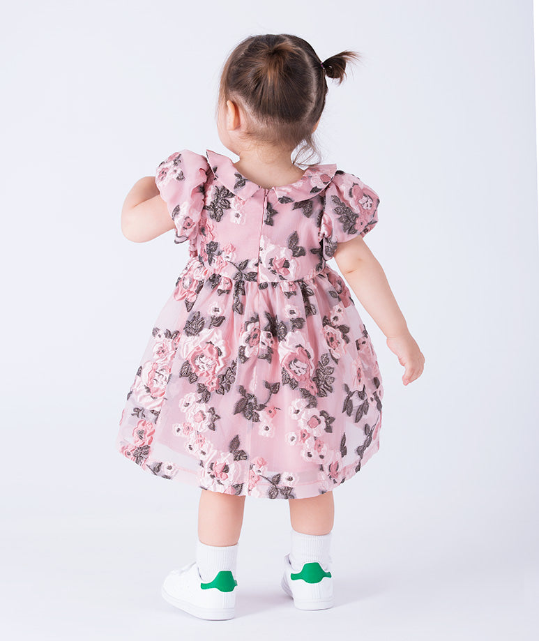A charming baby dress in soft pink with allover floral prints