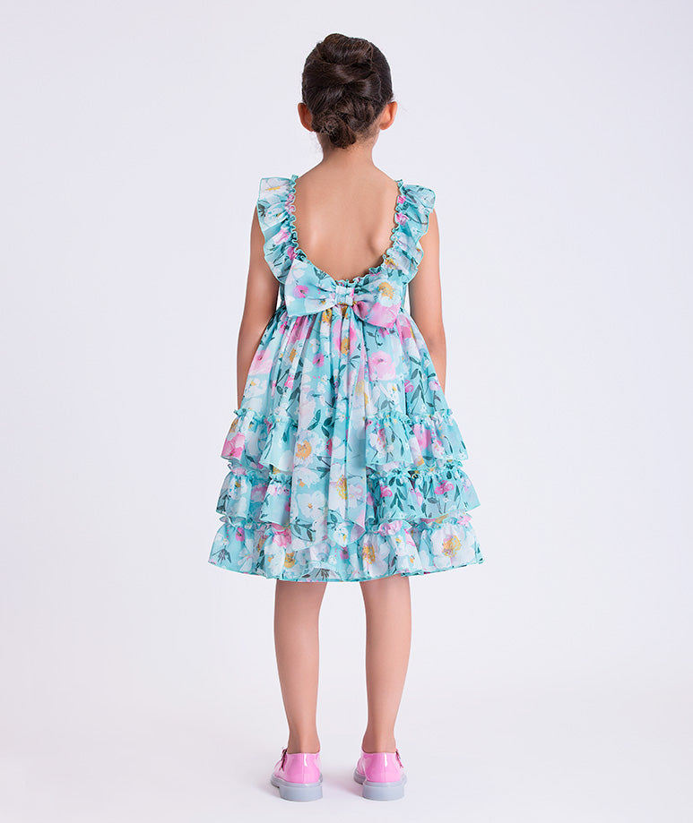 Back view of Enchanting Chiffon Girls Dress featuring tiered silhouette, open back detail, and flowing floral chiffon skirt.