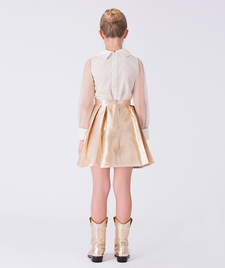 Back view of gold girls blouse and skirt set featuring sheer polka dot sleeves and metallic A-line skirt