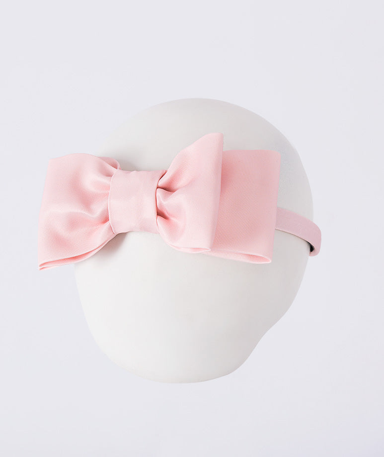 Mahe Lotus Bow Headband featuring a structured blush pink bow crafted from premium lightweight fabric, designed as an elegant hair accessory for birthdays, weddings, christenings, and special occasions.