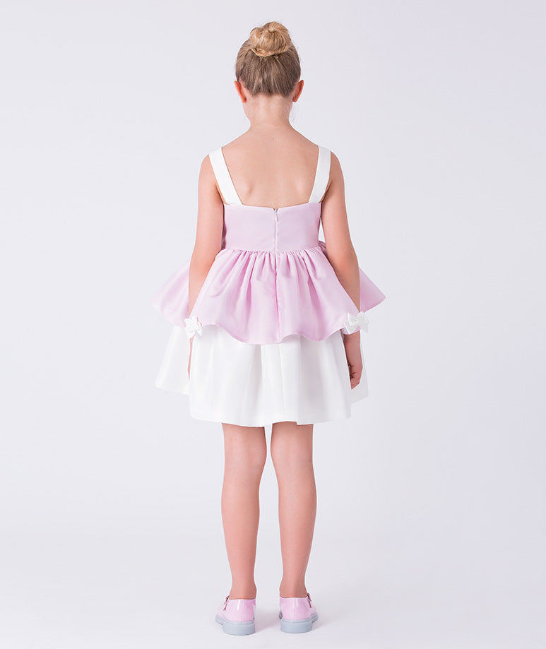 Back view of a pink layered flower girl dress with structured straps and soft volume, designed for weddings and formal celebrations.