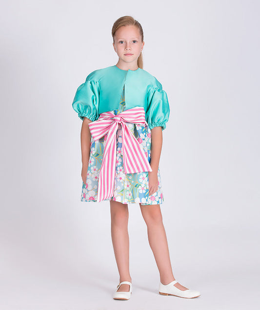 mint jacket with balloon sleeves and a blue floral dress with a pink and white striped bow on the waist