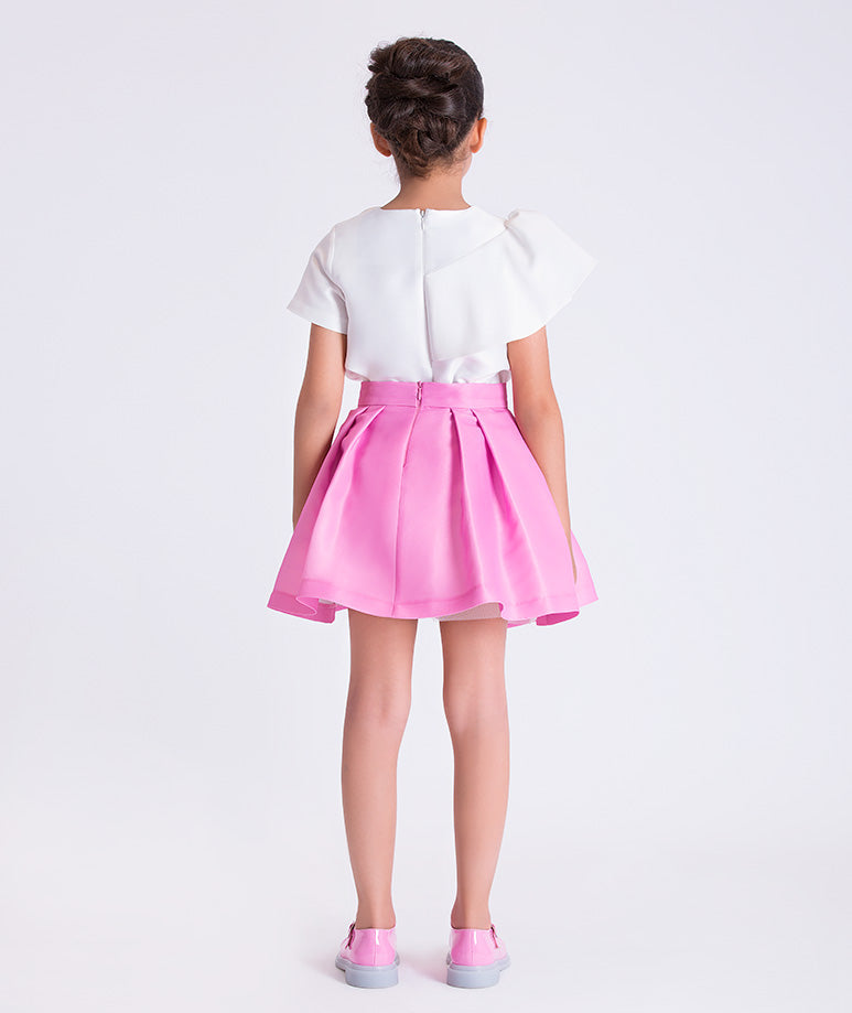 Back view of a two-piece girls outfit with structured top and softly flared skirt, designed for elegant celebrations.
