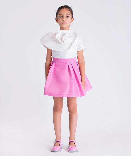 3D flower detail girls outfit worn by a 6-year-old girl, featuring a sculptural white top and flared pink skirt for special occasions.