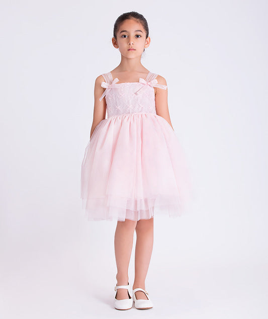 6 years old girl wearing a pink dress with bow details on a white background