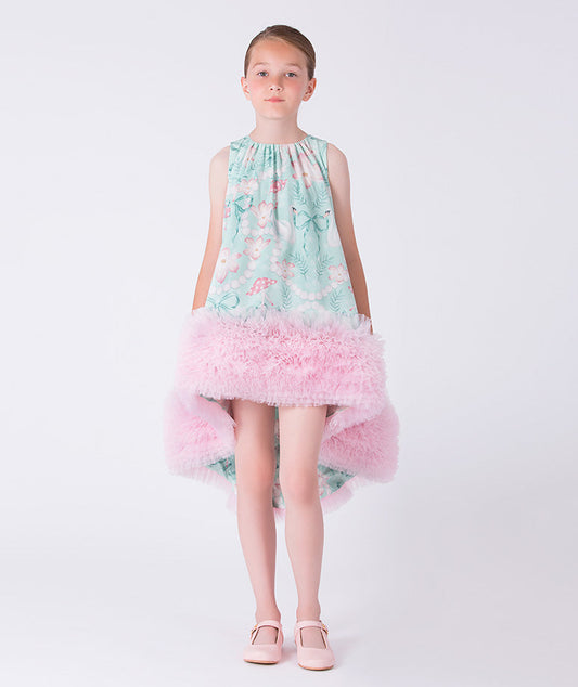 Young girl wearing a floral dress with a light blue top and pink ruffled skirt on a white background