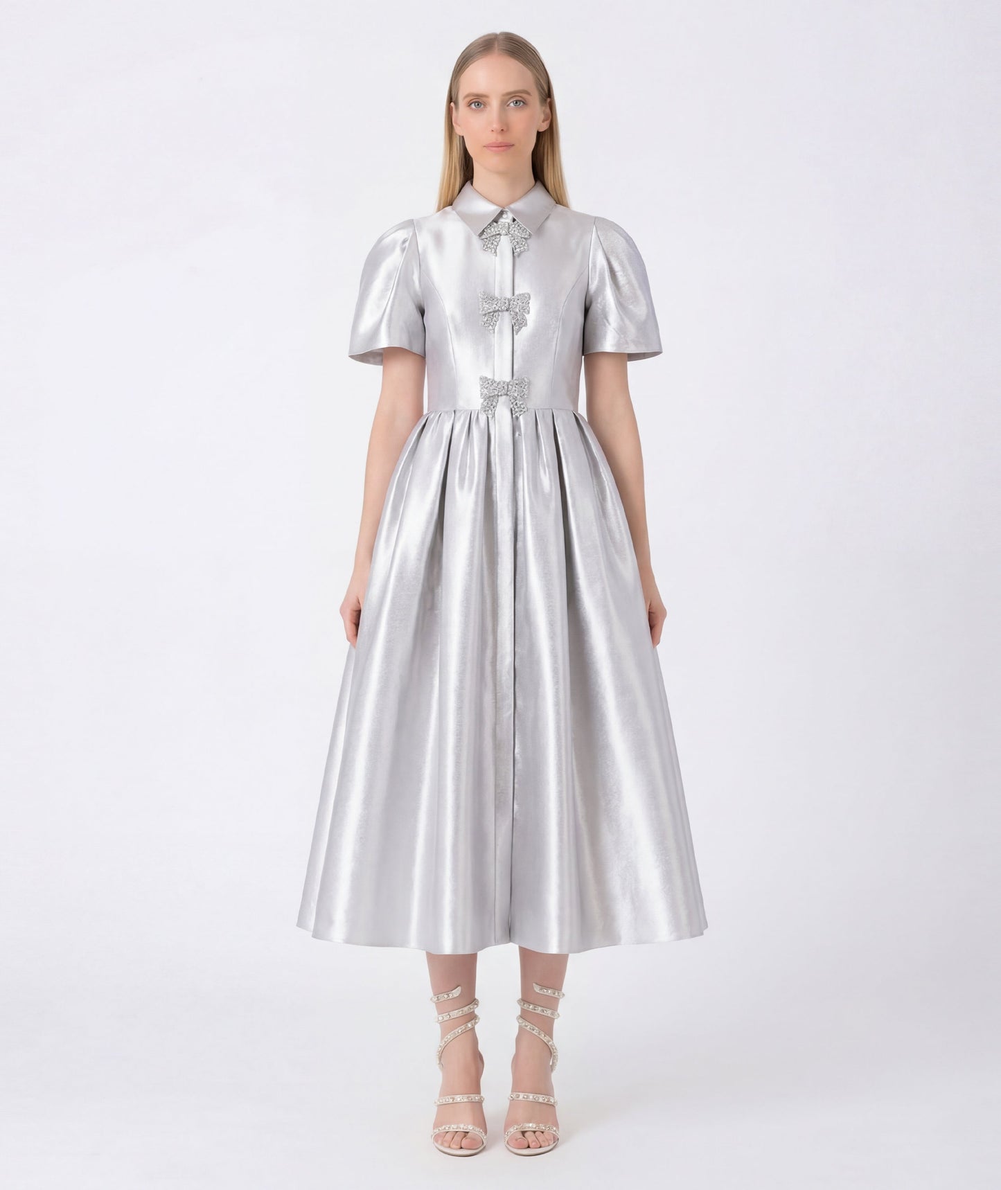 Woman wearing a silver metallic dress on a white background