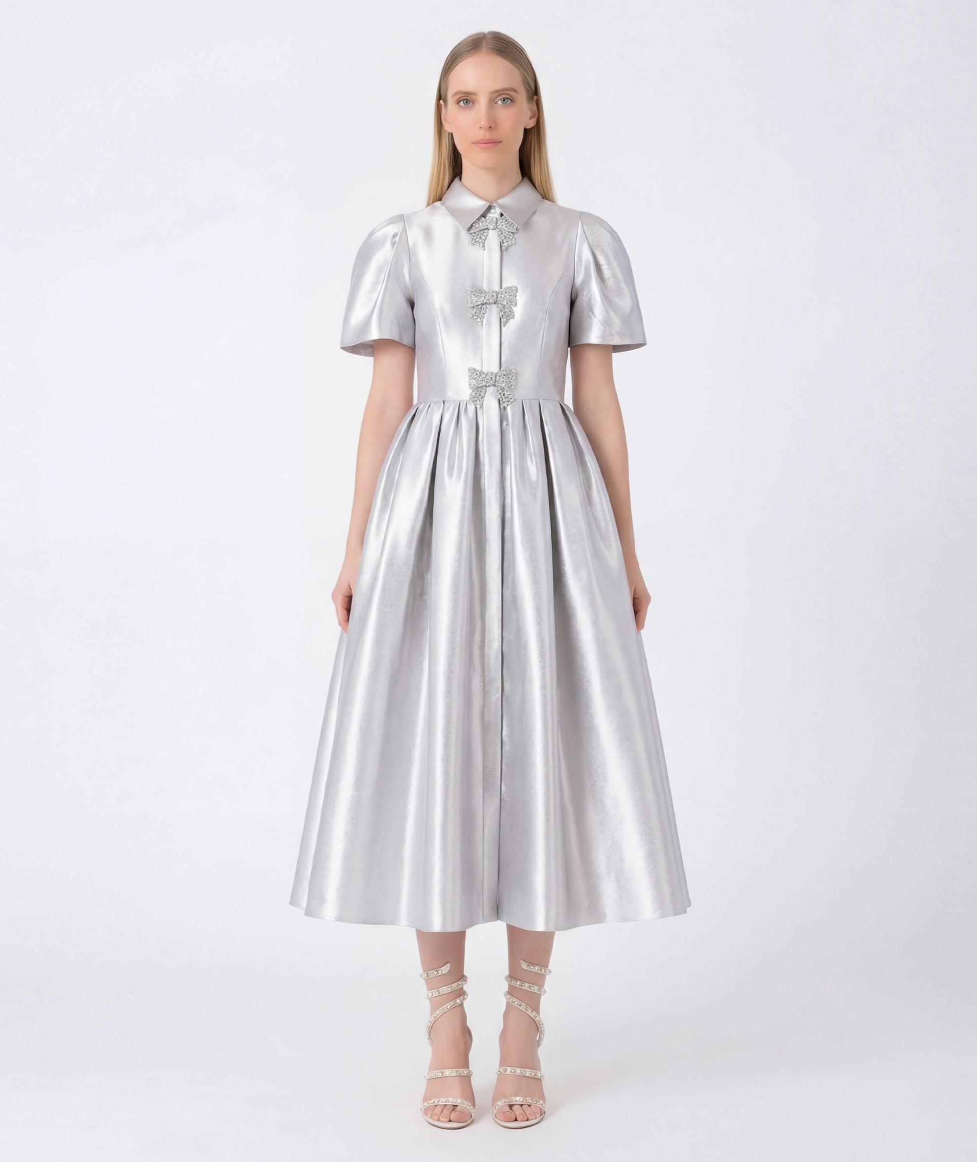 Woman wearing a silver metallic dress on a white background