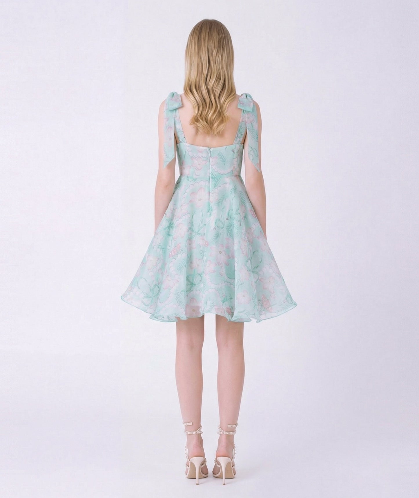 Woman wearing a light blue floral dress on a white background