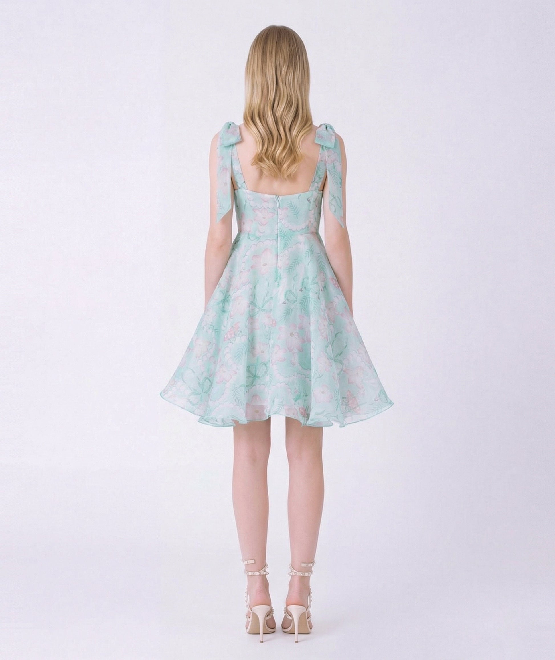 Woman wearing a light blue floral dress on a white background
