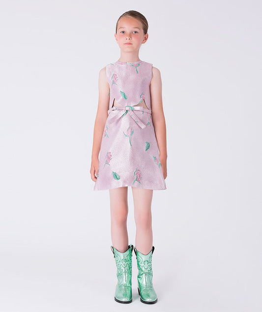 8 years old girl wearing a light purple dress with a floral pattern and green rain boots on a white background