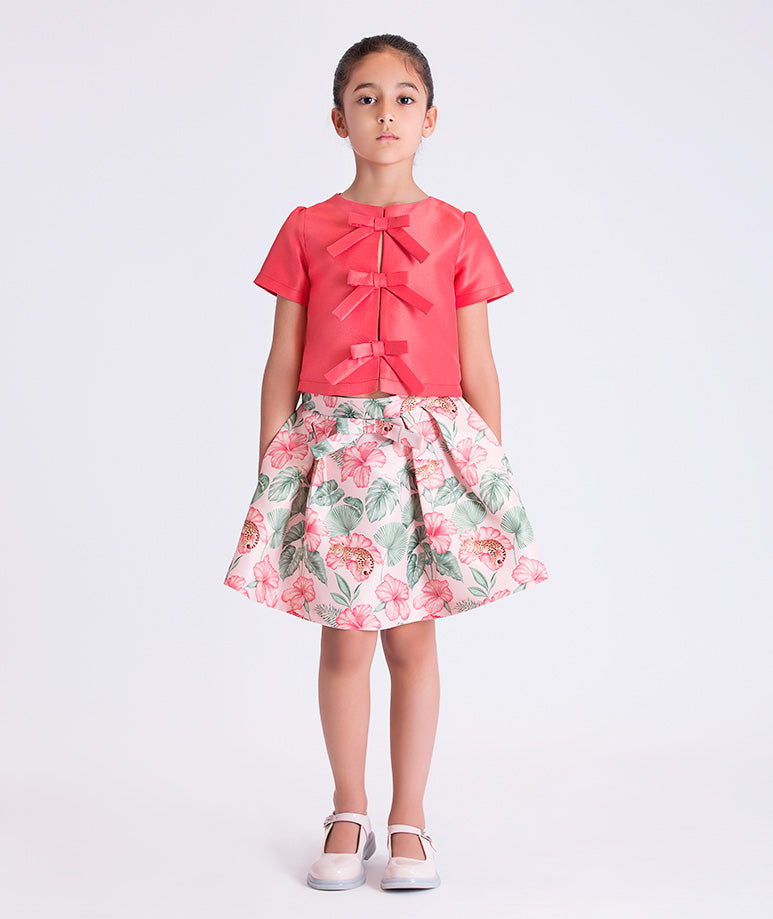 Front view of the Bow Enchanted Girls Outfit featuring a bow-detail short-sleeve top and floral skirt, crafted from premium lightweight fabric with cotton lining, designed for girls ages 3–12 for birthdays and special occasions.