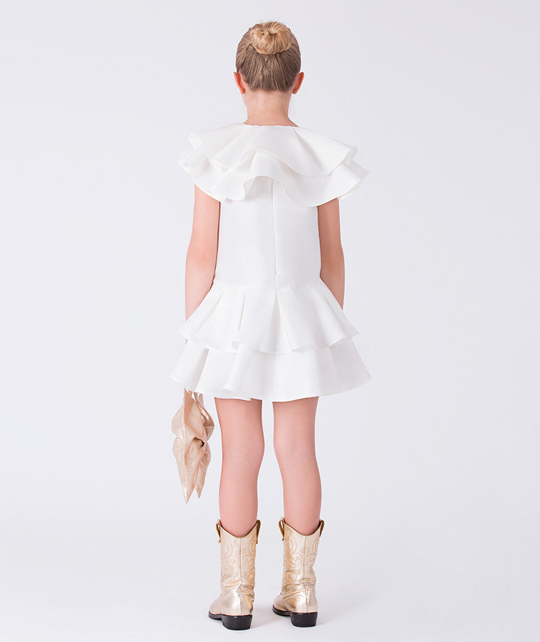 Back view of ivory girls dress featuring sculpted ruffle shoulders and tiered skirt design.