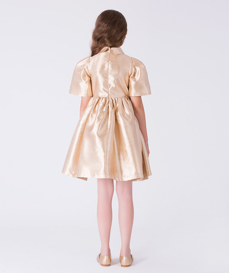 Back view of golden satin girls occasion dress with concealed zipper and softly gathered skirt silhouette.