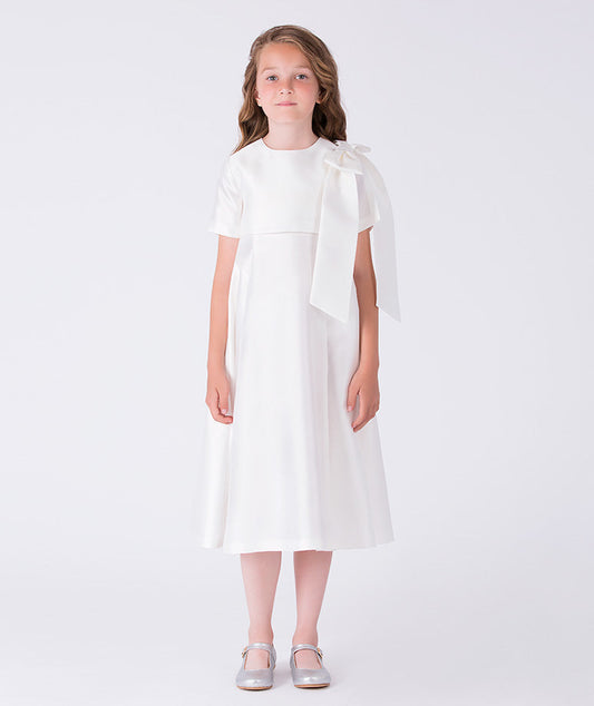 Front view of ivory girls ceremony dress with shoulder bow detail and below-the-knee A-line silhouette.
