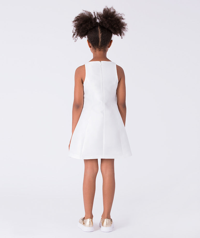 Back view of sleeveless ivory girls dress with concealed zipper and structured flared skirt design.