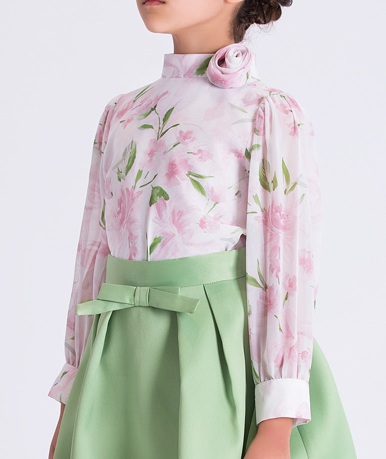 Close-up of the floral blouse and waist detail on a girls two-piece outfit, highlighting soft chiffon texture and refined tailoring for garden celebrations.