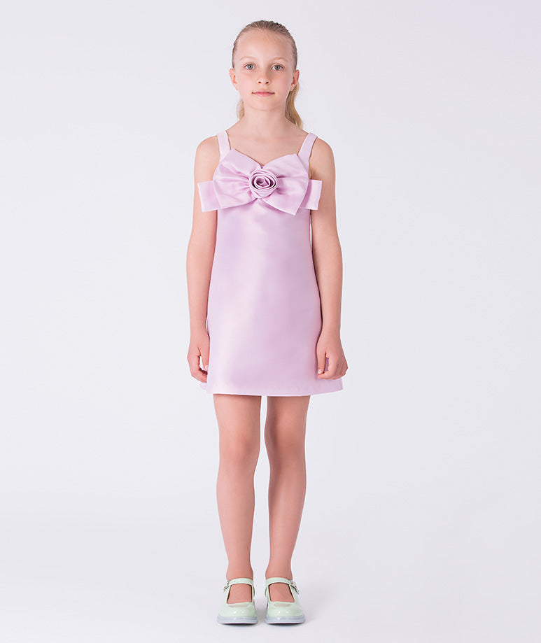 Front view of a pink girls dress with bow and rosette detail by Mama Luma, designed for weddings and summer celebrations.