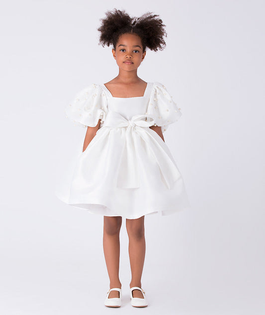 Front view of ivory girls dress with pearl beaded puff sleeves, square neckline and statement waist bow.
