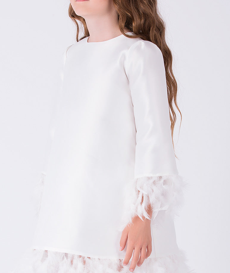 Close-up of feather trim cuffs on ivory long sleeve girls occasion dress with structured fabric.