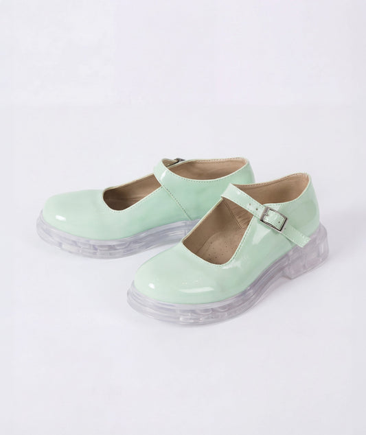 Pair of light green shoes with clear soles on a white background