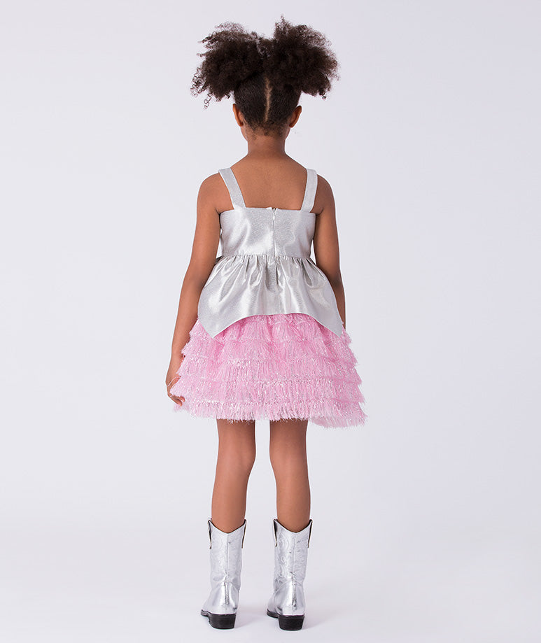 3 years old girl wearing a silver top and pink skirt with silver boots on a white background