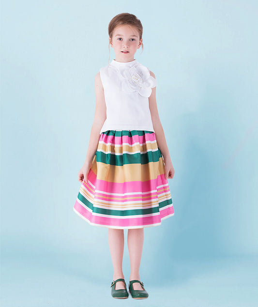 Classic sleeveless white blouse with an oversized floral applique, styled with a colorful striped midi skirt in shades of pink, green, and gold