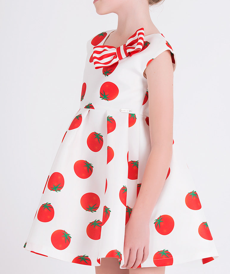 ecru dress with tomato prints and a red and white striped bow on the front