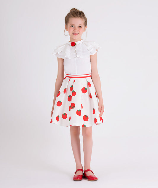 ecru blouse with ruffled neckline, red rose brooch and an ecru skirt with tomato prints