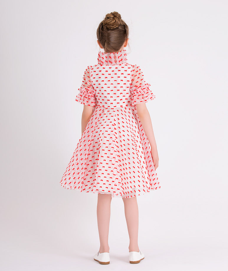 ecru organza dress with little red ribbons all over it