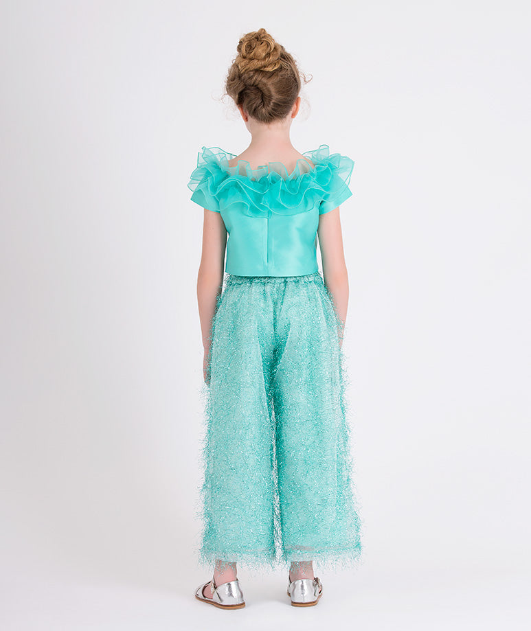 mint ruffled blouse and shimmery feathered pants