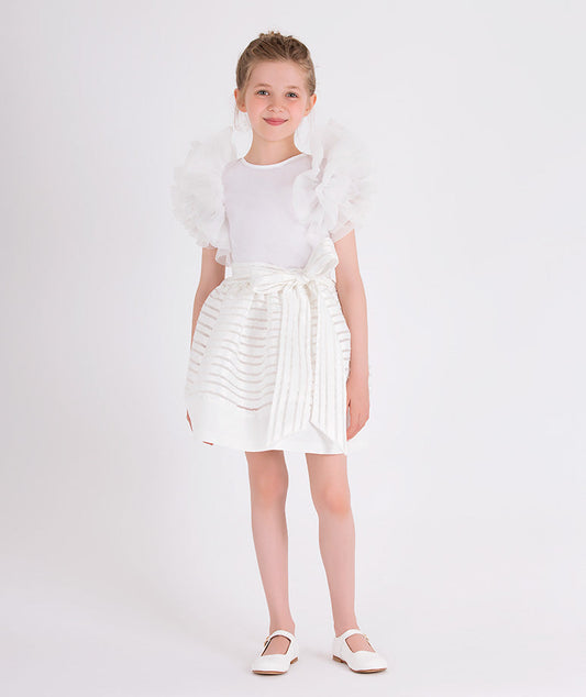 white blouse with ruffled sleeves and striped skirt with a bow on the waist