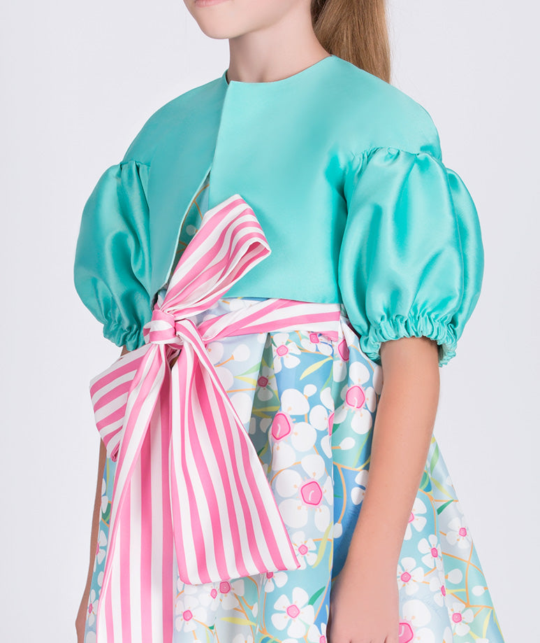 mint jacket with balloon sleeves and a blue floral dress with pink and white striped bow