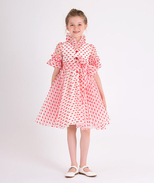 ecru dress with rose buttons and little red ribbons all over it 
